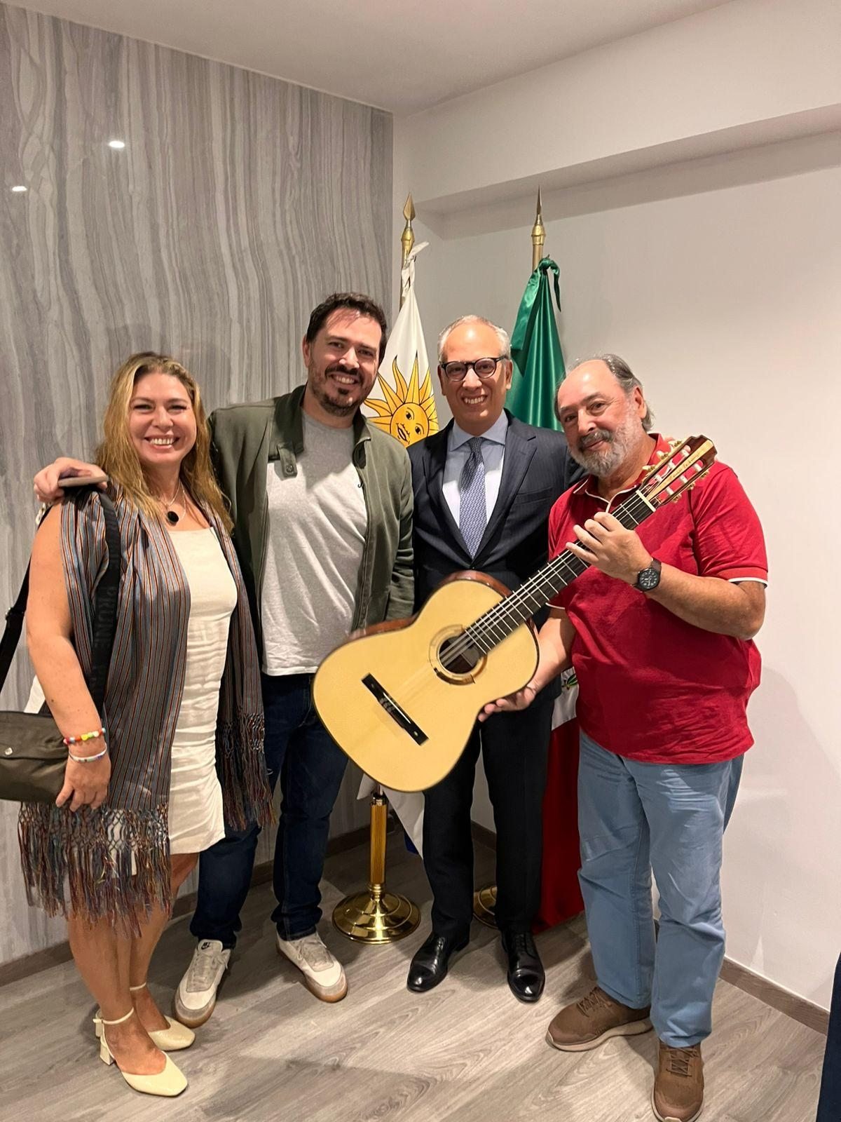 Tras la presentación, con una guitarra y ante las banderas de Uruguay y México